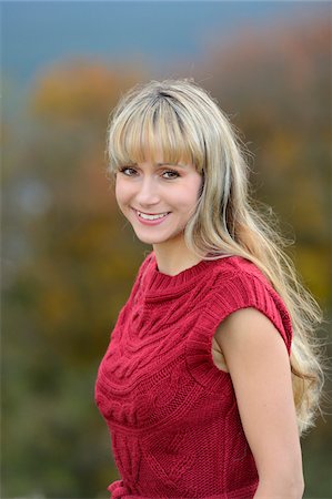 Portrait of Woman with Blond Hair Wearing Red Sleeveless Sweater Outdoors in Autumn Fotografie stock - Rights-Managed, Codice: 700-06531482