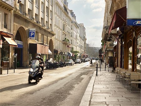 simsearch:700-06531927,k - Couple on three-wheeled scooter riding past shop-lined Saint-Dominique Street, Paris, France Stock Photo - Rights-Managed, Code: 700-06531975