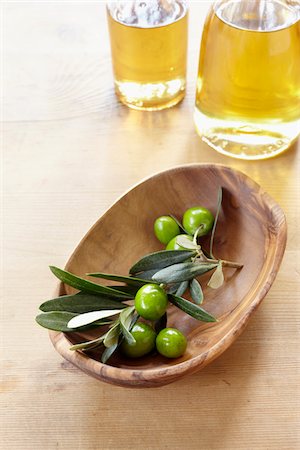 close-up of small wooden bowl with olive twig, fresh olives and bottle of olive oil Stock Photo - Rights-Managed, Code: 700-06899802
