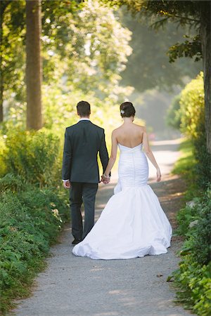 simsearch:700-05786584,k - Backview of Bride and Groom holding hands, walking down pathway outdoors, on Wedding Day Photographie de stock - Rights-Managed, Code: 700-06939705