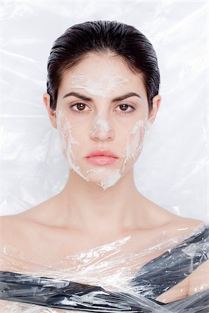 simsearch:700-06826406,k - Close-up Portrait of woman wrapped in plastic with cotton gauze on face, studio shot Stock Photo - Rights-Managed, Code: 700-06961984