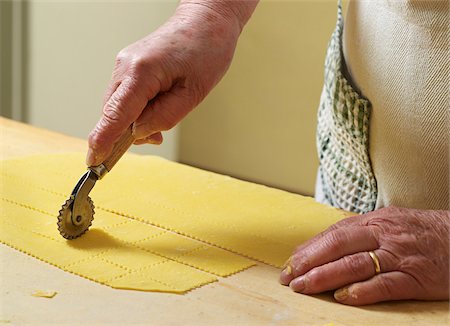 food closeup - Close-up of elderly Italian woman making pasta by hand in kitchen, cutting pasta dough with rotary tool, Ontario, Canada Stock Photo - Rights-Managed, Code: 700-07108323