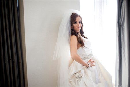 simsearch:600-03783424,k - Portrait of bride standing next to window, smiling and looking at camera, Ontario, Canada Stock Photo - Rights-Managed, Code: 700-07199844