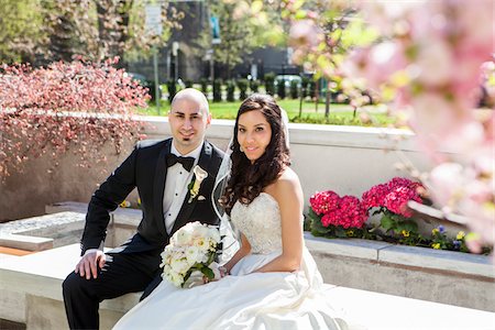 simsearch:700-07199878,k - Portrait of Bride and groom sitting on stone bench in park in Spring, smiling and looking at camera, Canada Stock Photo - Rights-Managed, Code: 700-07237621