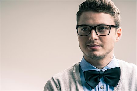 simsearch:700-07278871,k - Close-up portrait of student, young man wearing bow tie and eyeglasses, studio shot on whtie background Photographie de stock - Rights-Managed, Code: 700-07278864