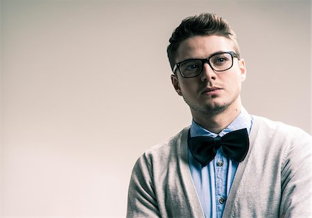 people studio - Close-up portrait of student, young man wearing bow tie and eyeglasses looking into the distance, studio shot on white background Foto de stock - Con derechos protegidos, Código: 700-07278865