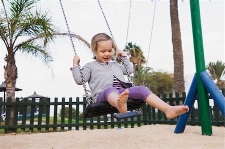 Three year old girl playing in playground on swing, Spain Foto de stock - Con derechos protegidos, Código: 700-07311135