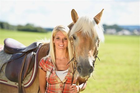 Close-up portrait of a young woman standing beside her Haflinger horse in a field in summer, Upper Palatinate, Bavaria, Germany Photographie de stock - Rights-Managed, Code: 700-07734364