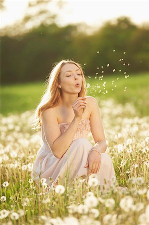 daydreamer - Young woman sitting in a withered dandelion meadow in spring, Germany Stock Photo - Rights-Managed, Code: 700-08080547