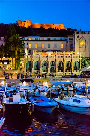 restaurant people - Boats docked at marina with the Venetian Loggia and the Hvar Fortress overlooking the harbour at night in the Old Town of Hvar on Hvar Island, Croatia Foto de stock - Con derechos protegidos, Código: 700-08765422