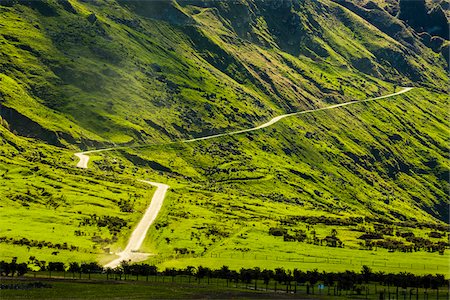 Green fields on mountainside with widning road to the Treble Cone ski area at Glendhu Bay in the Otago Region of New Zealand Stock Photo - Rights-Managed, Code: 700-08765542