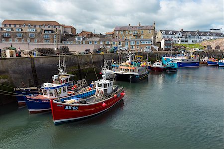 Harbour with fishing boats docked at seawall in the village of Seahouses in Northumberland, England, United Kingdom Stock Photo - Rights-Managed, Code: 700-09013949