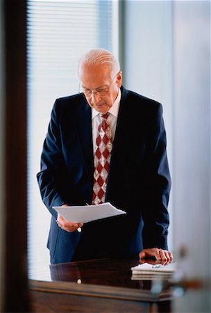 Mature homme d'affaires à la recherche de documents Photographie de stock - Rights-Managed, Code: 700-00025025