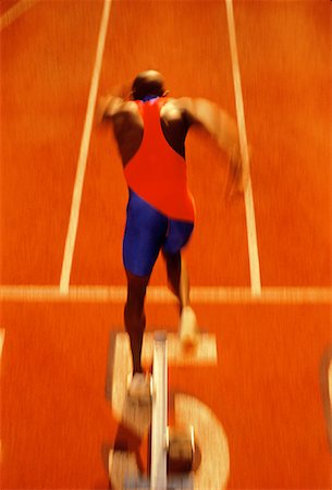 Back View of Male Runner Leaving Starting Block Stock Photo - Rights-Managed, Code: 700-00025443