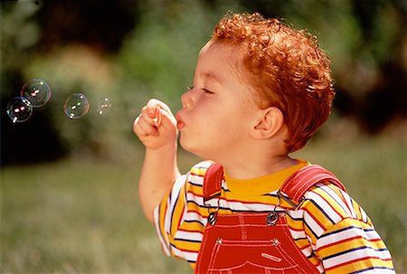 simsearch:632-05604245,k - Boy Blowing Bubbles Outdoors Stock Photo - Rights-Managed, Code: 700-00025635