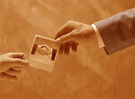 Businessmen Holding Photograph of Handshake Stock Photo - Rights-Managed, Code: 700-00028550