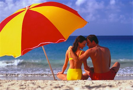 simsearch:700-00021491,k - Vue arrière du Couple en maillot de bain assis sur la plage avec parasol Photographie de stock - Rights-Managed, Code: 700-00021172