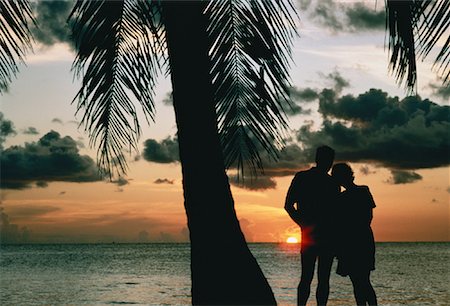 simsearch:700-00021491,k - Silhouette de Couple debout sur la plage près de palmiers au coucher du soleil Photographie de stock - Rights-Managed, Code: 700-00044881