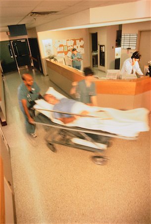 simsearch:632-01613036,k - Blurred View of Doctors Wheeling Patient through Hospital Stock Photo - Rights-Managed, Code: 700-00040998