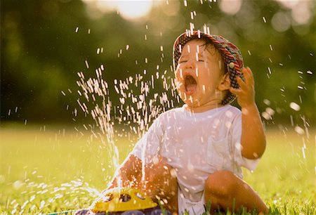 Child Playing with Sprinkler Stock Photo - Rights-Managed, Code: 700-00042336