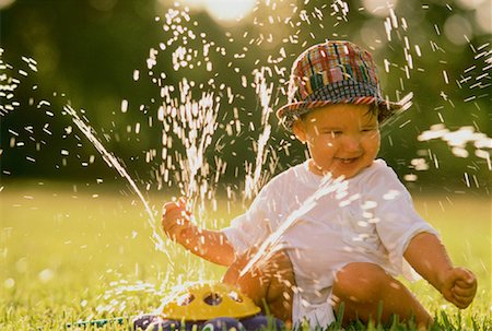 Child Playing with Sprinkler Stock Photo - Rights-Managed, Code: 700-00042337