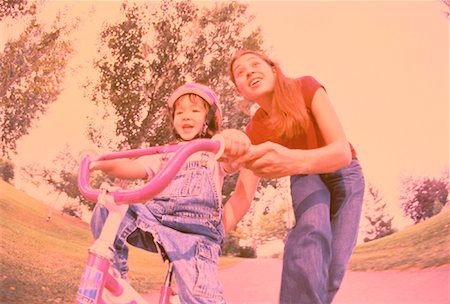 simsearch:700-03067843,k - Mother Helping Daughter Learn to Ride Bicycle in Park Stock Photo - Rights-Managed, Code: 700-00054166