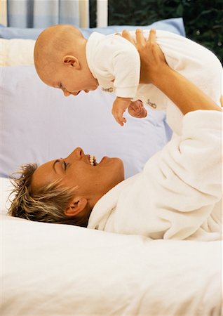 simsearch:700-00080994,k - Mother Lying on Bed, Holding Baby Face to Face Stock Photo - Rights-Managed, Code: 700-00054379