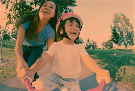 simsearch:700-03067843,k - Mother Helping Daughter Ride Bicycle in Park Stock Photo - Rights-Managed, Code: 700-00054695