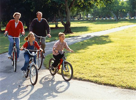 simsearch:400-06412547,k - Family Riding Bicycles on Pathway Through Park Stock Photo - Rights-Managed, Code: 700-00055384