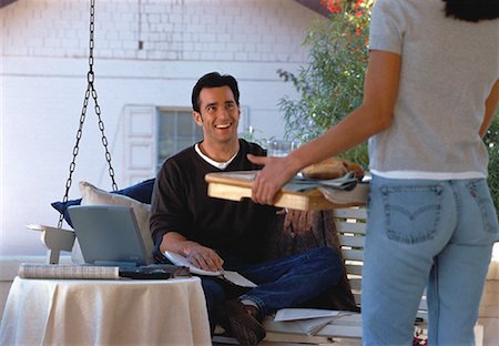 Woman Bringing Lunch to Man Working on Laptop on Porch Stock Photo - Rights-Managed, Code: 700-00055749