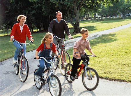 simsearch:400-06412547,k - Family Riding Bicycles on Pathway In Park Stock Photo - Rights-Managed, Code: 700-00056035