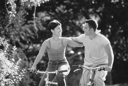 simsearch:700-00549929,k - Couple Riding Bicycles Arm in Arm In Park Stock Photo - Rights-Managed, Code: 700-00051420