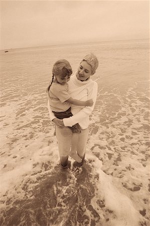 Grandmother Standing in Surf on Beach, Holding Granddaughter Stock Photo - Rights-Managed, Code: 700-00064747