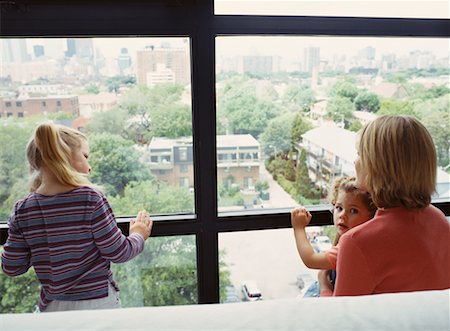 Back View of Mother and Daughters Looking Out of Window Stock Photo - Rights-Managed, Code: 700-00065541