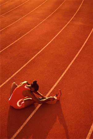 pictures of female athletes bending over - Back View of Female Athlete Sitting on Track, Stretching Legs Stock Photo - Rights-Managed, Code: 700-00068519