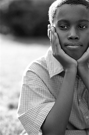 Portrait of Boy Sitting Outdoors Resting Head on Hands Stock Photo - Rights-Managed, Code: 700-00069958