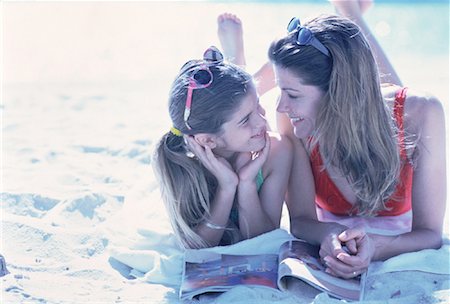 Mother and Daughter in Swimwear Lying on Beach with Magazine Stock Photo - Rights-Managed, Code: 700-00060466