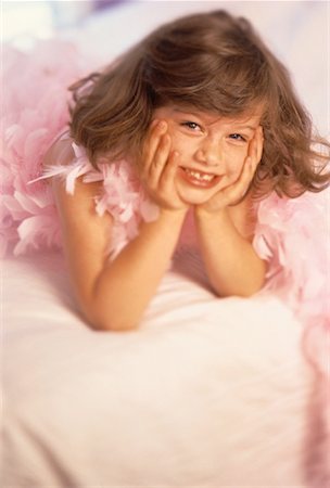 feather boa - Portrait de jeune fille allongée sur le lit portant Boa rose Photographie de stock - Rights-Managed, Code: 700-00061475