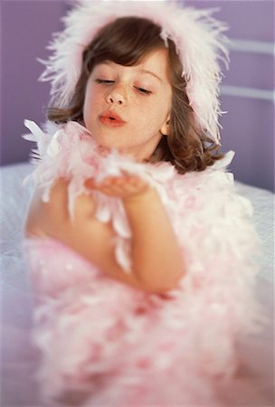 feather boa - Portrait de jeune fille assise sur le lit portant Boa rose Photographie de stock - Rights-Managed, Code: 700-00061478