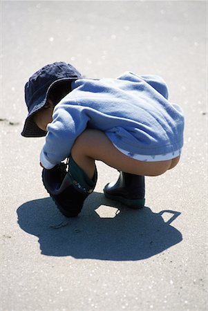 Young Boy Crouching on Beach Stock Photo - Rights-Managed, Code: 700-00074125