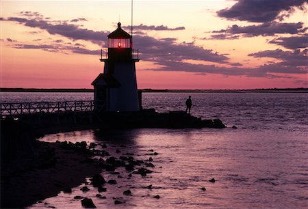 Silhouette of Person Standing on Rocks near Lighthouse at Sunset Nantucket, Massachusetts, USA Stock Photo - Rights-Managed, Code: 700-00074489