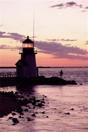 Silhouette of Person Standing on Rocks near Lighthouse at Sunset Nantucket, Massachusetts, USA Stock Photo - Rights-Managed, Code: 700-00074490