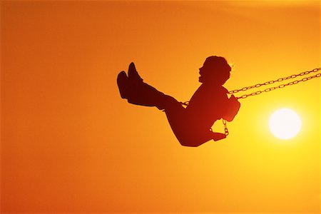 Silhouette of Child on Swing at Sunset Stock Photo - Rights-Managed, Code: 700-00077921