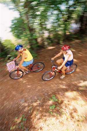 senior women mountain biking - Blurred View of Mature Couple Riding Bikes through Forest Stock Photo - Rights-Managed, Code: 700-00085265