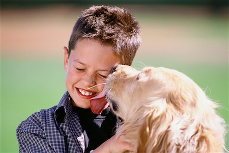 simsearch:700-00071488,k - Dog Licking Boy's Face Outdoors Stock Photo - Rights-Managed, Code: 700-00085401