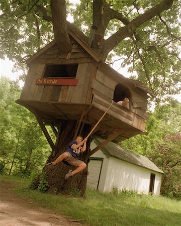 Boy Swinging on Rope by Tree House Stock Photo - Rights-Managed, Code: 700-00089515