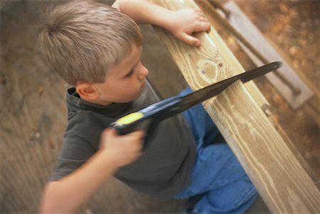 Boy Cutting Wood for Tree House Stock Photo - Rights-Managed, Code: 700-00081385