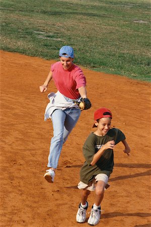 Mother Chasing After Son at Baseball Diamond Stock Photo - Rights-Managed, Code: 700-00083589