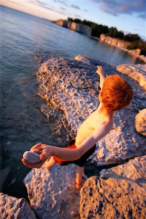 Boy Throwing Rocks Off Cliff Stock Photo - Rights-Managed, Code: 700-00098662