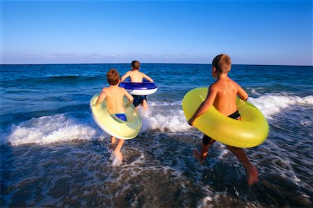 simsearch:700-00020587,k - Children Running on Beach with Inner Tubes Stock Photo - Rights-Managed, Code: 700-00150968